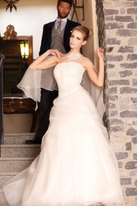 Abito con corpetto drappeggiato e pizzo rebrodè ricamato a a mano con gonna in organza leggerissima